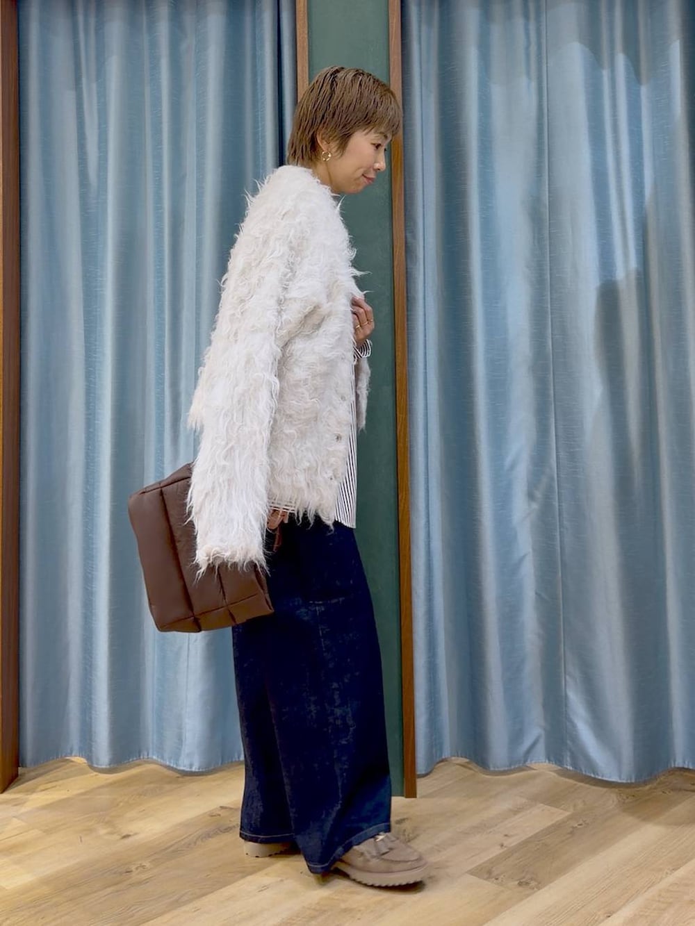ベージュ系のシャツ/ブラウス、ブラウン系のトートバッグ、ブルー系のデニムパンツを着用したレディースの秋コーディネートの7枚目の写真