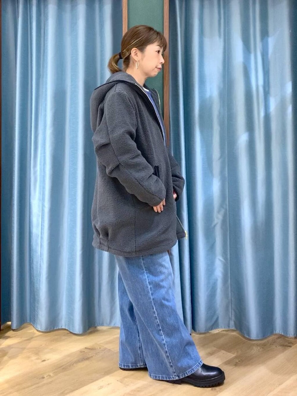 ブラック系のブーツ、ブルー系のデニムパンツ、ブルー系のニット/セーターを着用したレディースの冬コーディネートの4枚目の写真