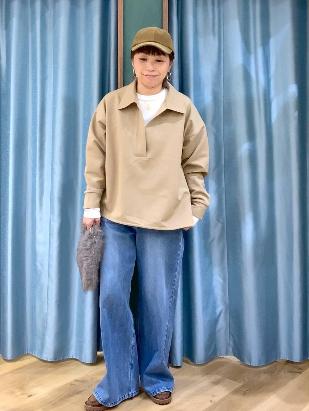 ブルー系のデニムパンツ、ブラウン系のトートバッグ、ブラウン系のローファーを着用したレディースの冬コーディネートの5枚目の写真