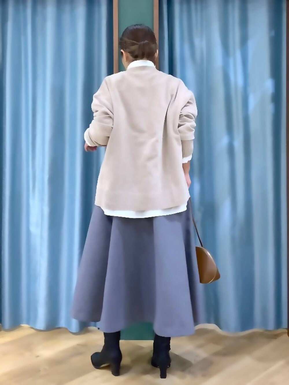 イエロー系のトートバッグ、ホワイト系のシャツ/ブラウス、ベージュ系のニット/セーターを着用したレディースの秋コーディネートの5枚目の写真