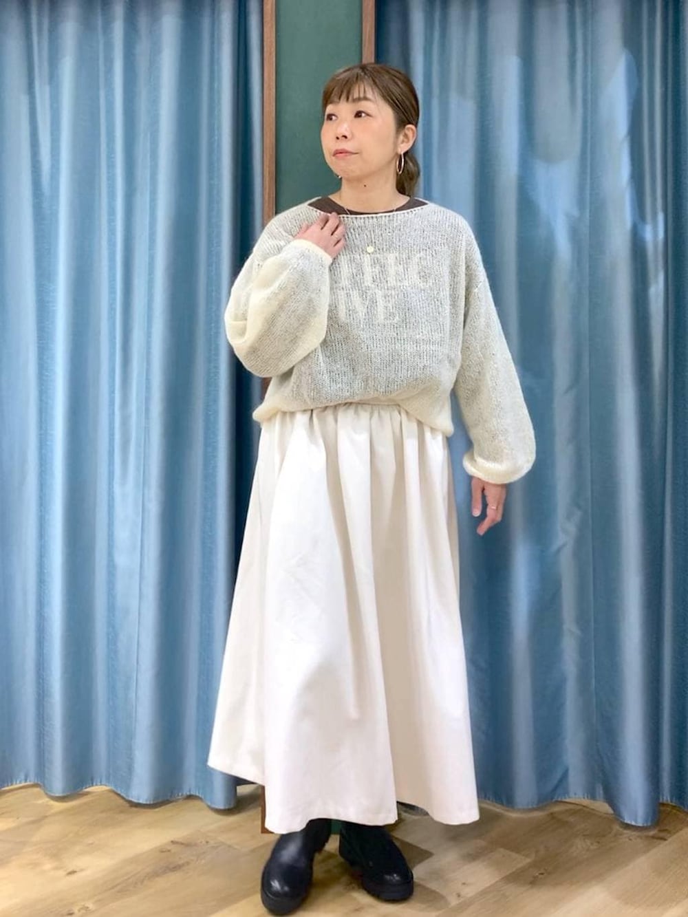 ブラック系のブーツ、ホワイト系のスカート、ホワイト系のニット/セーターを着用したレディースの冬コーディネートの8枚目の写真