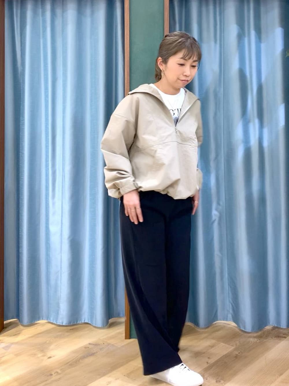 ブラック系のスラックス、ベージュ系のブルゾン、ホワイト系のTシャツ/カットソーを着用したレディースの冬コーディネートの2枚目の写真