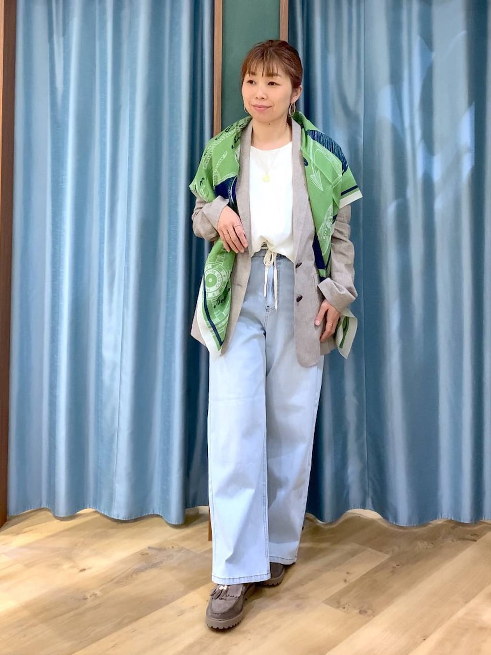 グレー系のローファー、ブルー系のデニムパンツ、ベージュ系のテーラードジャケットを着用したレディースの春コーディネートの3枚目の写真