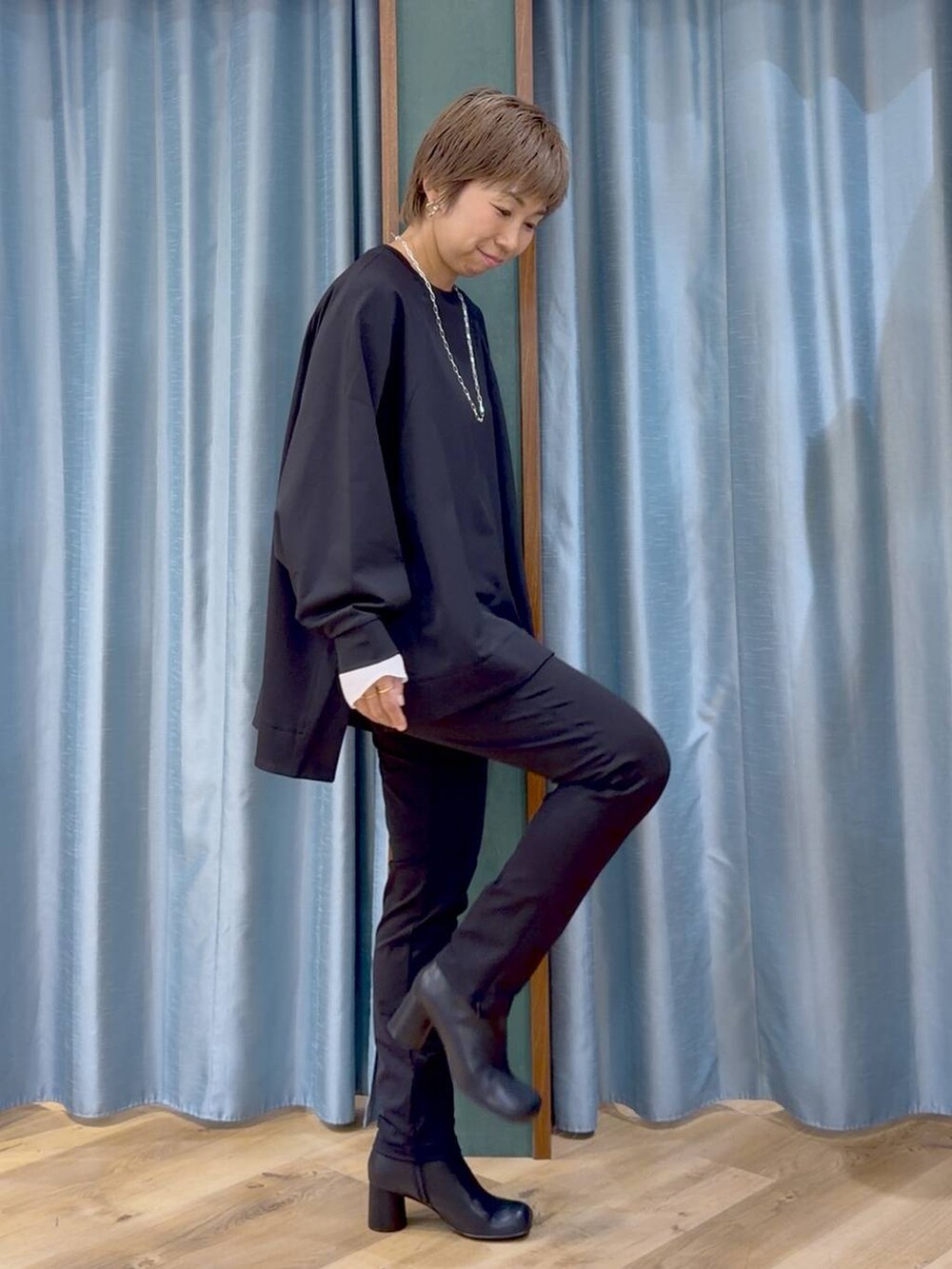 ブラック系のその他パンツ、ブラック系のブーツ、ホワイト系のTシャツ/カットソーを着用したレディースの秋コーディネートの3枚目の写真