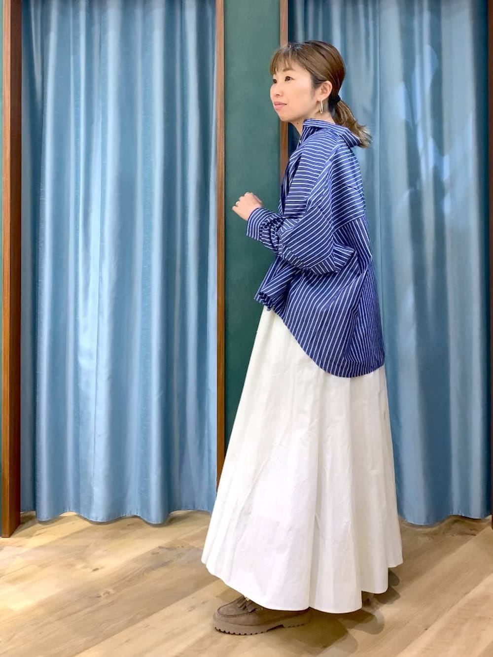 ベージュ系のローファー、ホワイト系のスカート、ブルー系のシャツ/ブラウスを着用したレディースの春コーディネートの6枚目の写真