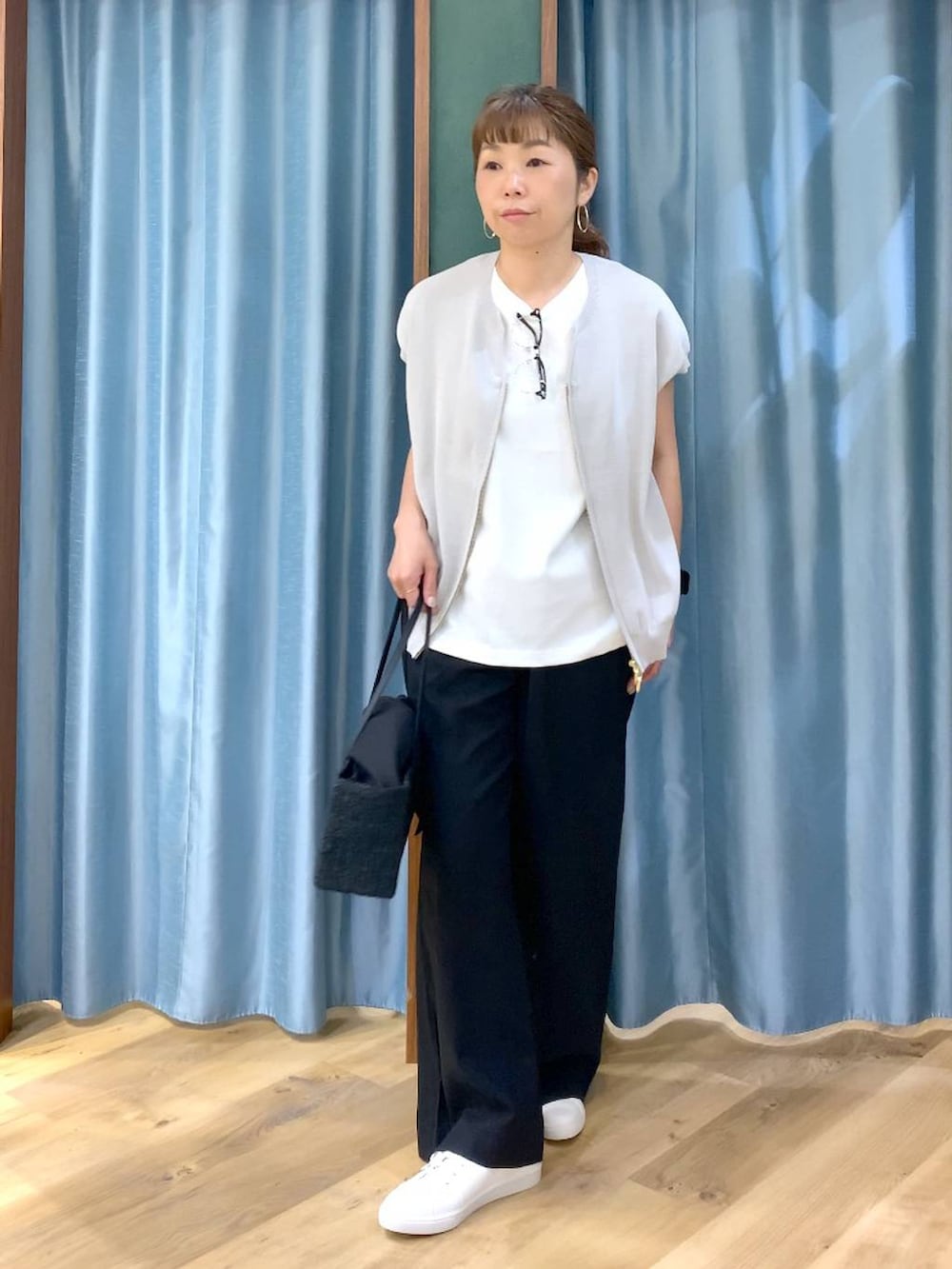 ホワイト系のTシャツ/カットソー、グレー系のニット/セーター、ブラック系のその他パンツを着用したレディースの春コーディネートの2枚目の写真