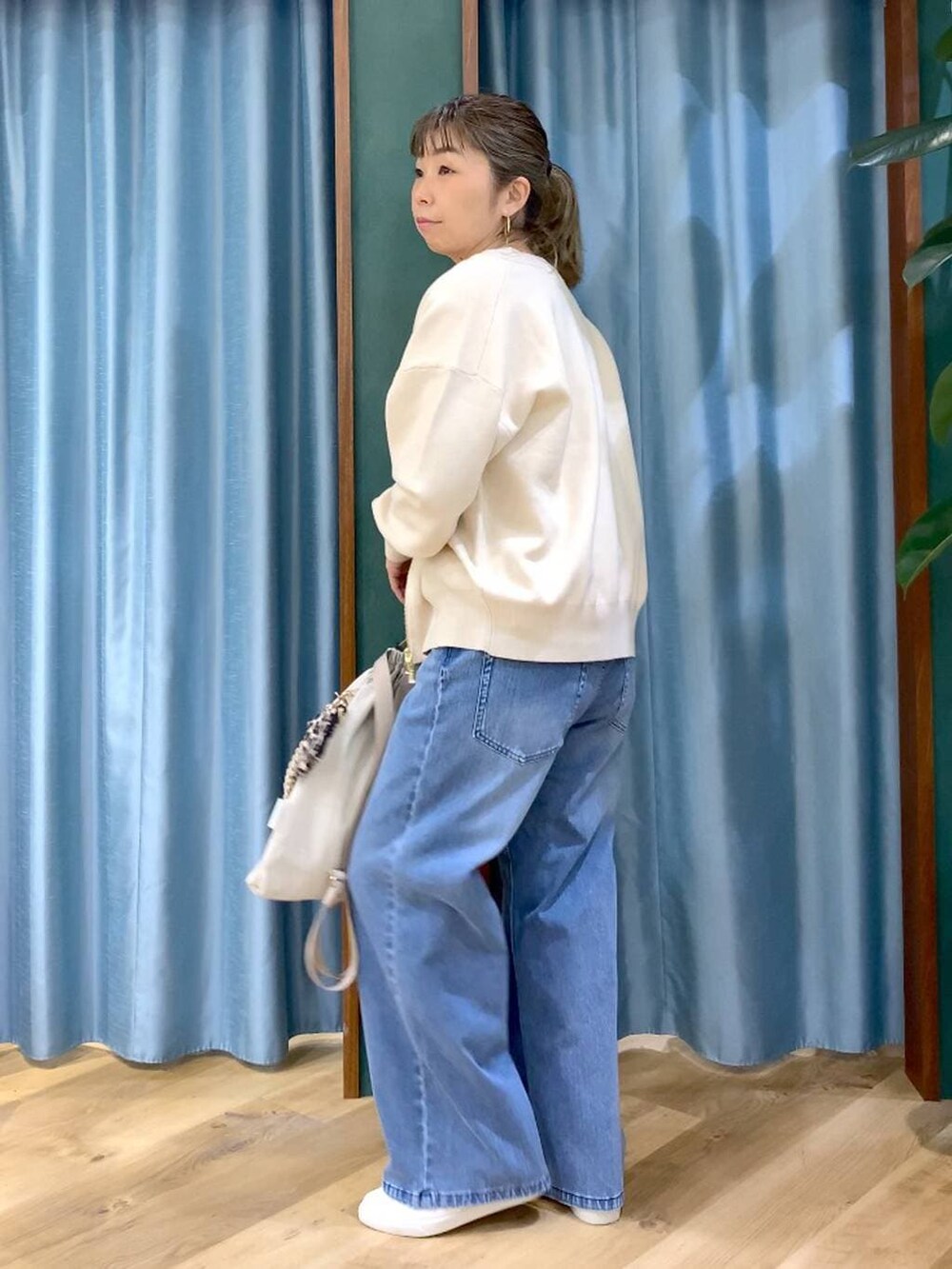 ホワイト系のカーディガン/ボレロ、ブルー系のデニムパンツ、ホワイト系のTシャツ/カットソーを着用したレディースの冬コーディネートの5枚目の写真