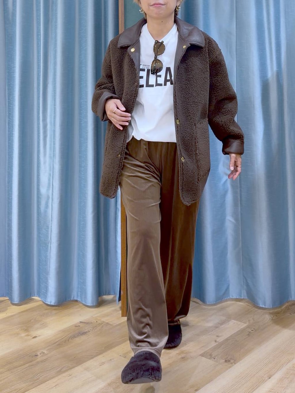 ブラウン系のムートンコート、ブラウン系のその他シューズ、ホワイト系のTシャツ/カットソーを着用したレディースの秋コーディネートの9枚目の写真