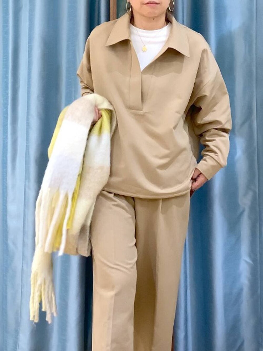 ホワイト系のTシャツ/カットソー、イエロー系のシャツ/ブラウス、イエロー系のスラックスを着用したレディースの冬コーディネートの5枚目の写真