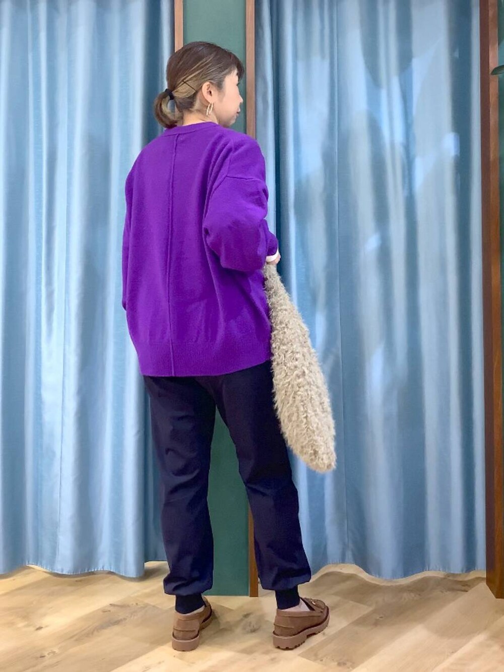 パープル系のニット/セーター、ベージュ系のハンドバッグ、ブルー系のその他パンツを着用したレディースの秋コーディネートの2枚目の写真