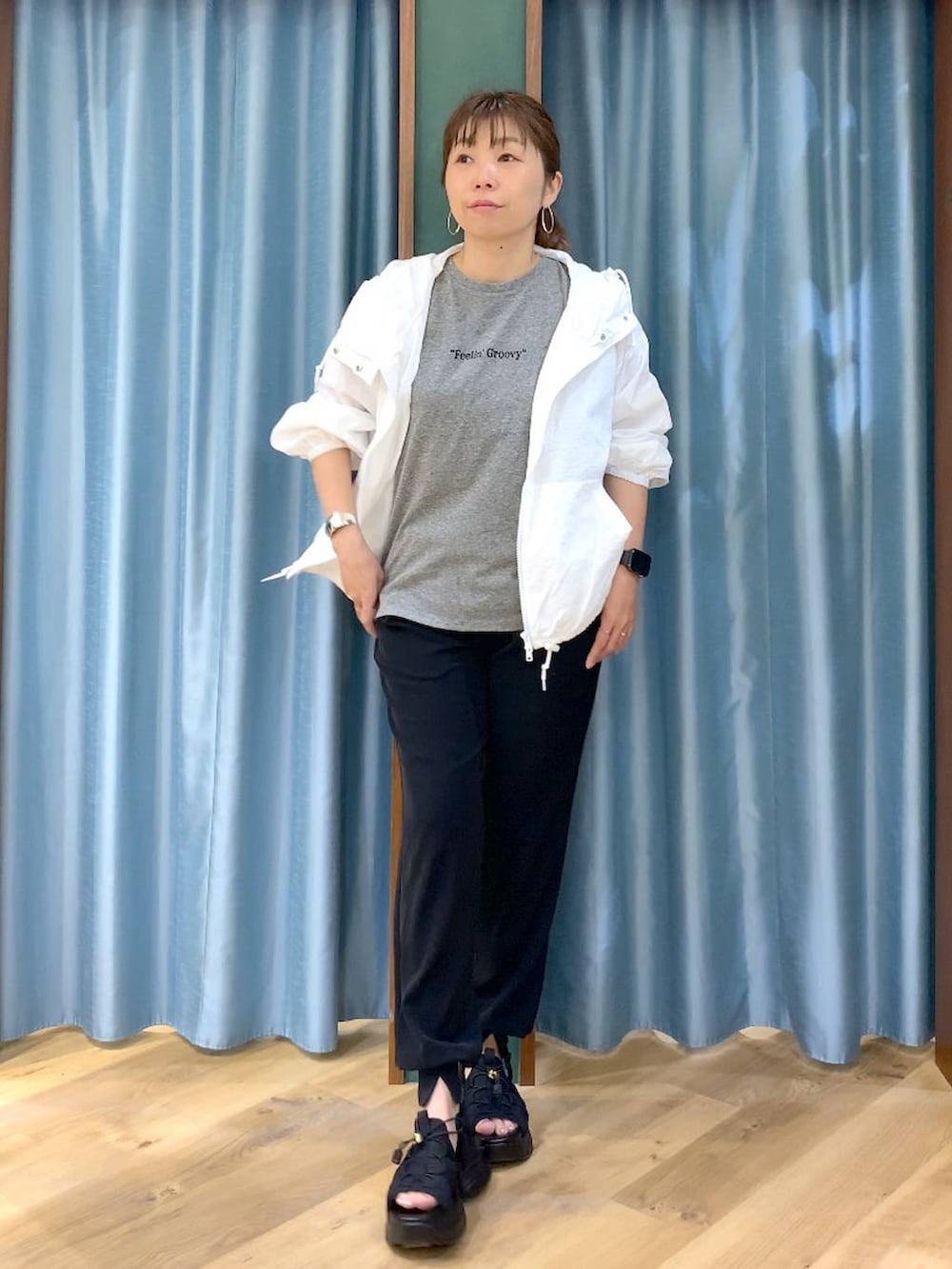 ホワイト系のブルゾン、グレー系のTシャツ/カットソー、ブラック系のサンダルを着用したレディースの春コーディネートの2枚目の写真