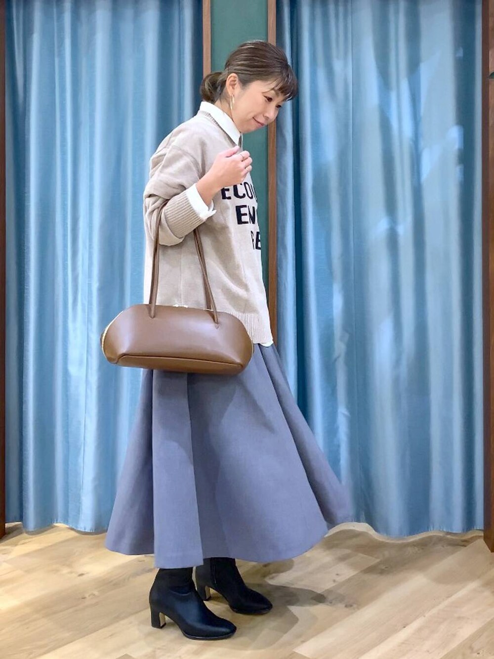 イエロー系のトートバッグ、ホワイト系のシャツ/ブラウス、ベージュ系のニット/セーターを着用したレディースの秋コーディネートの4枚目の写真