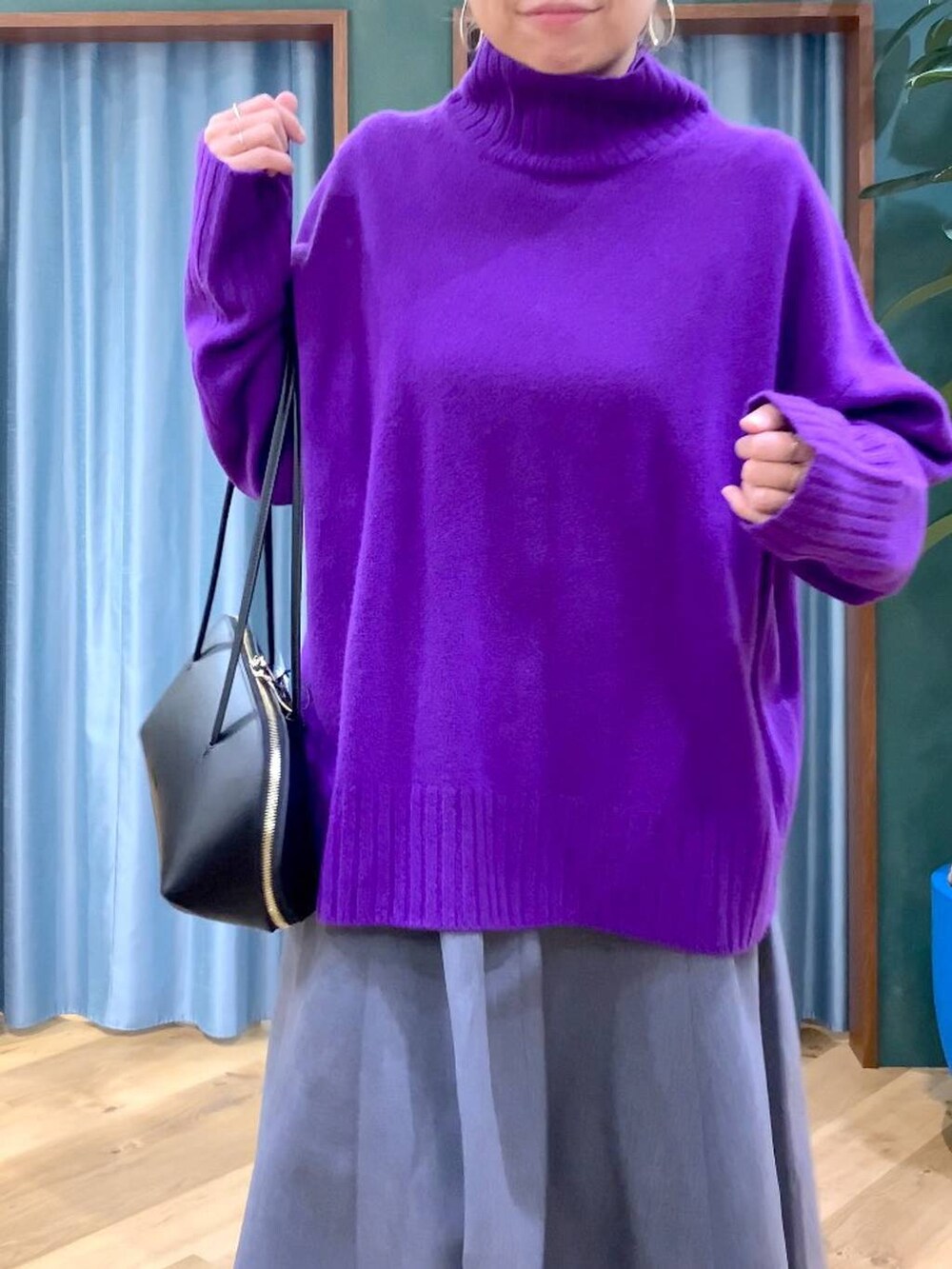 ブラック系のトートバッグ、グレー系のスカート、ブラック系のブーツを着用したレディースの秋コーディネートの9枚目の写真