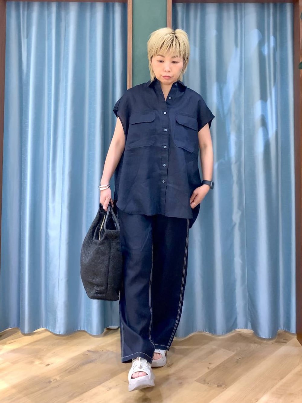 ブルー系のその他パンツ、グレー系のサンダル、ブルー系のシャツ/ブラウスを着用したレディースの夏コーディネートの2枚目の写真