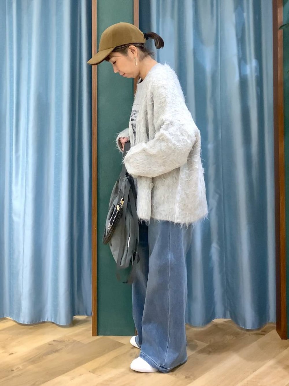 ブルー系のデニムパンツ、グレー系のTシャツ/カットソー、グレー系のバックパック/リュックを着用したレディースの秋コーディネートの6枚目の写真