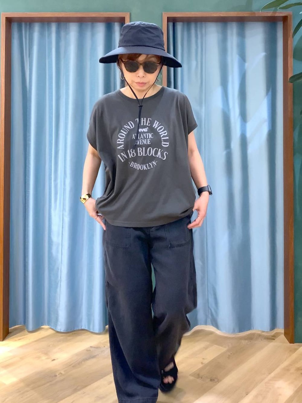 ブラック系のTシャツ/カットソー、グレー系のデニムパンツ、ブラック系のサンダルを着用したレディースの春コーディネートの7枚目の写真