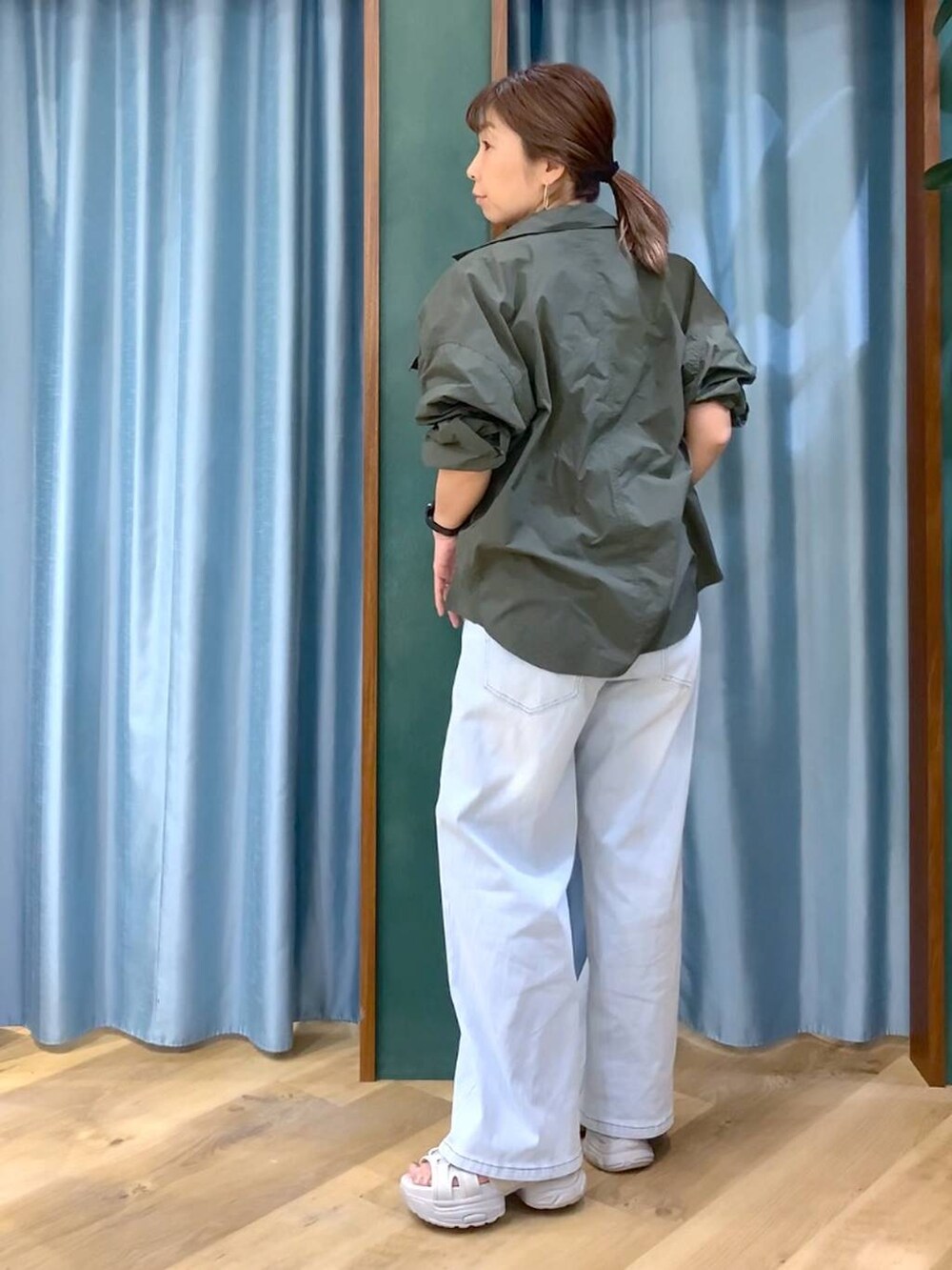 ブルー系のデニムパンツ、ホワイト系のTシャツ/カットソー、グレー系のサンダルを着用したレディースの春コーディネートの6枚目の写真
