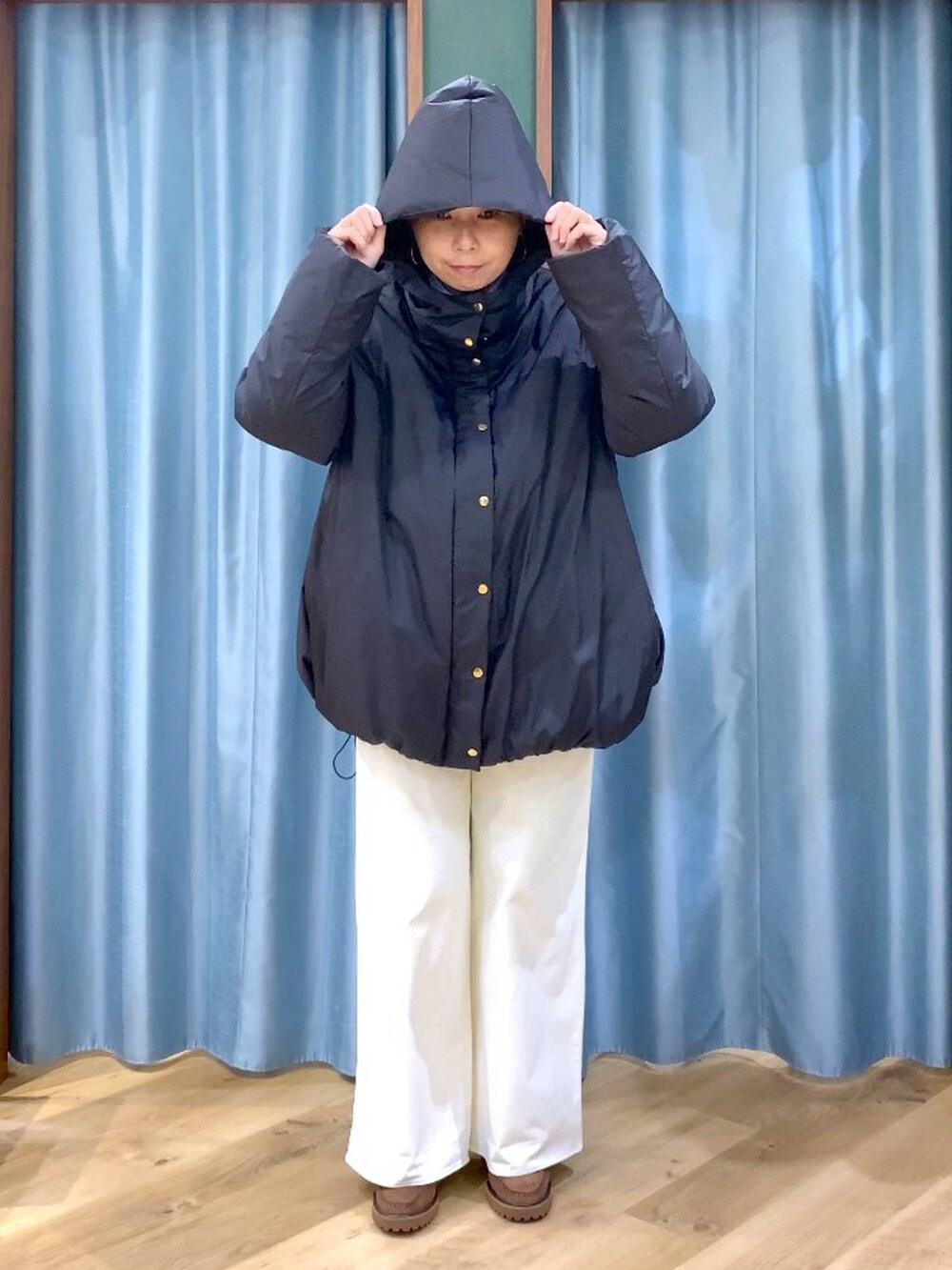 ブルー系のシャツ/ブラウス、ブラック系のダウンジャケット/コート、ブラウン系のローファーを着用したレディースの秋コーディネートの4枚目の写真