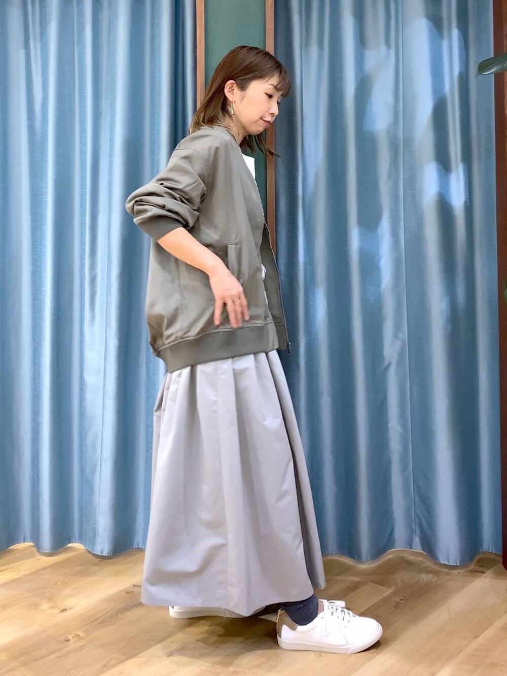 グレー系のスカート、グリーン系のMA-1、ホワイト系のTシャツ/カットソーを着用したレディースの冬コーディネートの4枚目の写真