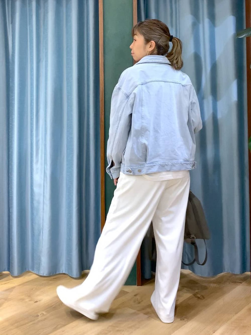 ホワイト系のスラックス、ブルー系のデニムジャケット、ホワイト系のTシャツ/カットソーを着用したレディースの冬コーディネートの8枚目の写真