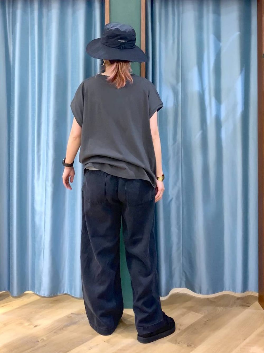 ブラック系のTシャツ/カットソー、グレー系のデニムパンツ、ブラック系のサンダルを着用したレディースの春コーディネートの6枚目の写真