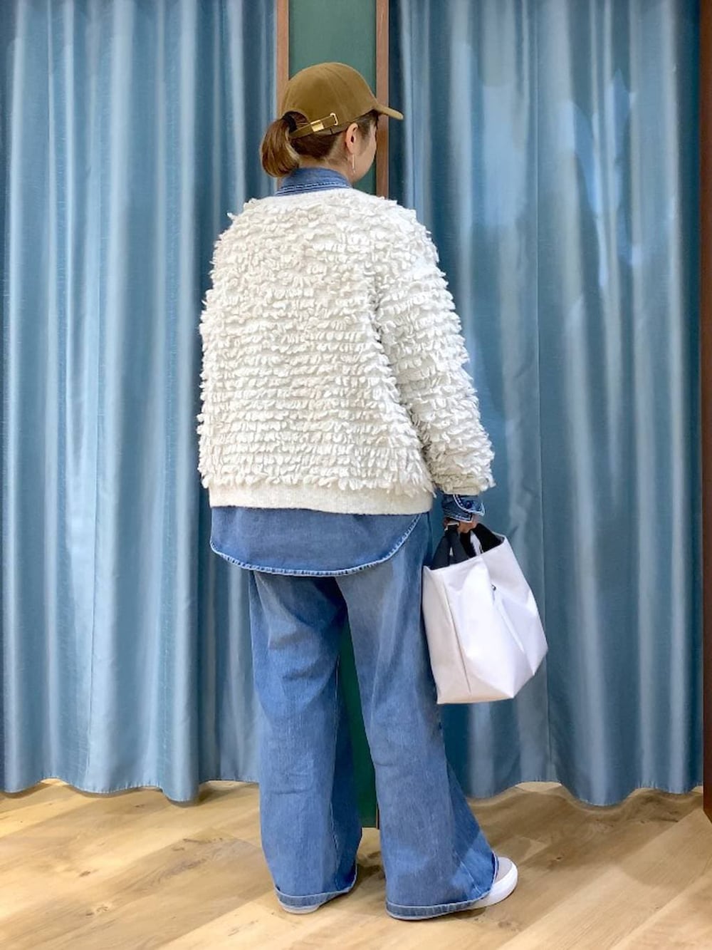 ブルー系のシャツ/ブラウス、ブルー系のデニムパンツ、ベージュ系のスニーカーを着用したレディースの冬コーディネートの4枚目の写真