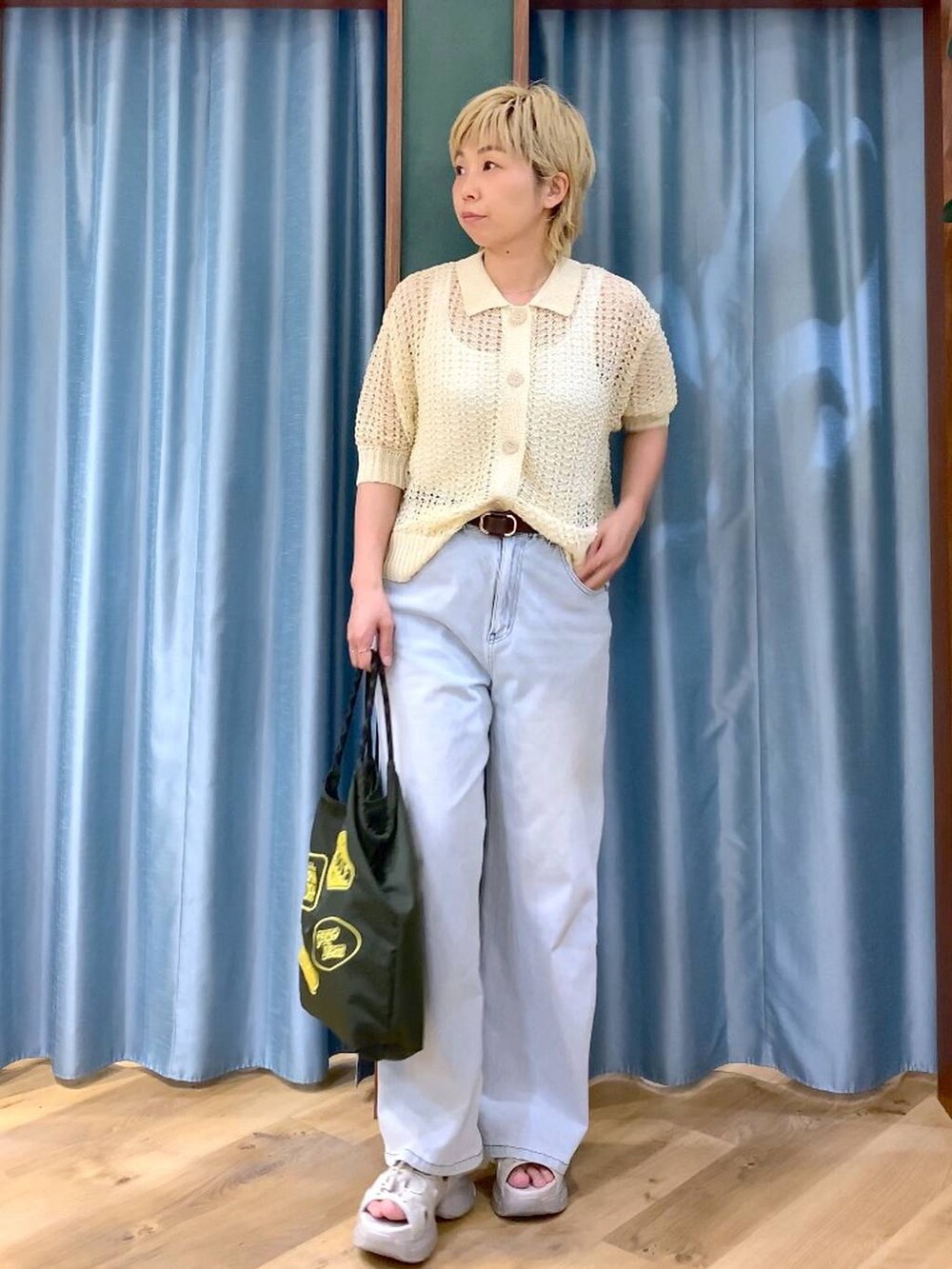 ホワイト系のタンクトップ、ブルー系のデニムパンツ、ホワイト系のニット/セーターを着用したレディースの夏コーディネートの5枚目の写真