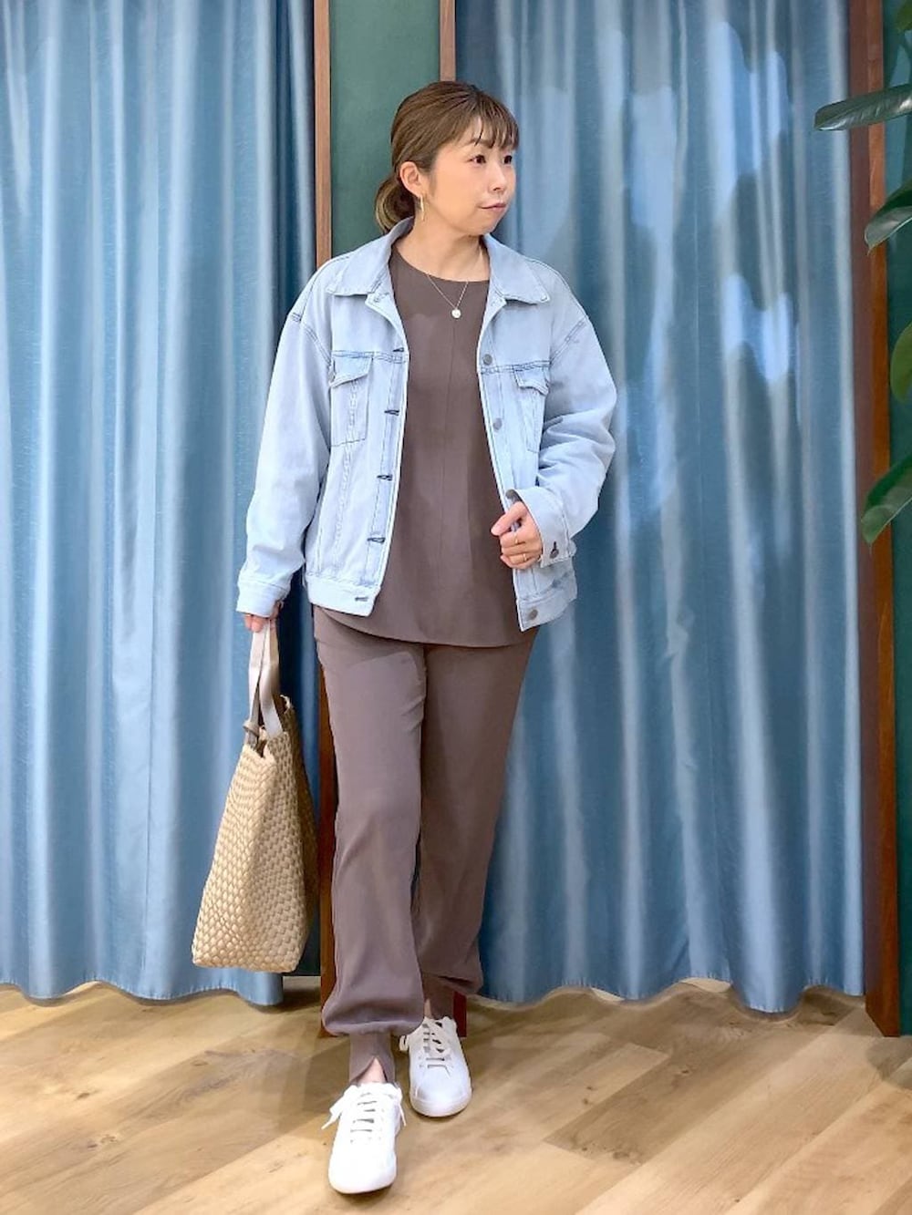 ブルー系のデニムジャケット、グリーン系のTシャツ/カットソー、ベージュ系のトートバッグを着用したレディースの冬コーディネートの3枚目の写真