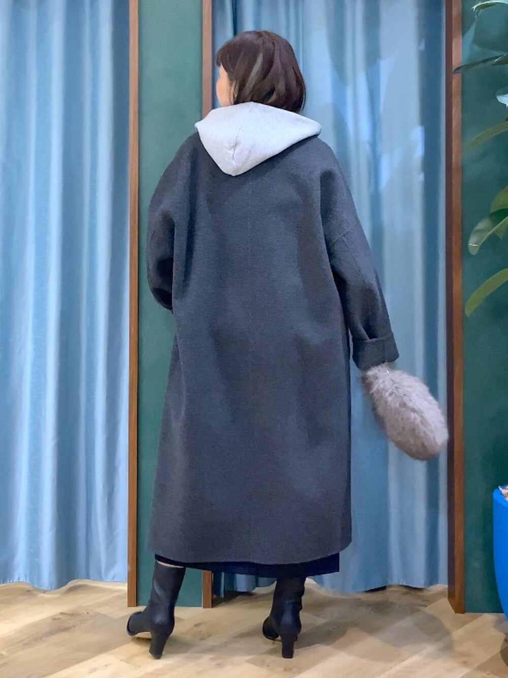 ブラウン系のトートバッグ、グレー系のチェスターコート、ブラック系のスカートを着用したレディースの秋コーディネートの6枚目の写真