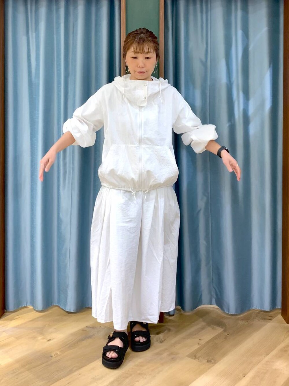 ホワイト系のスカート、ホワイト系のブルゾン、ブラック系のトートバッグを着用したレディースの春コーディネートの7枚目の写真