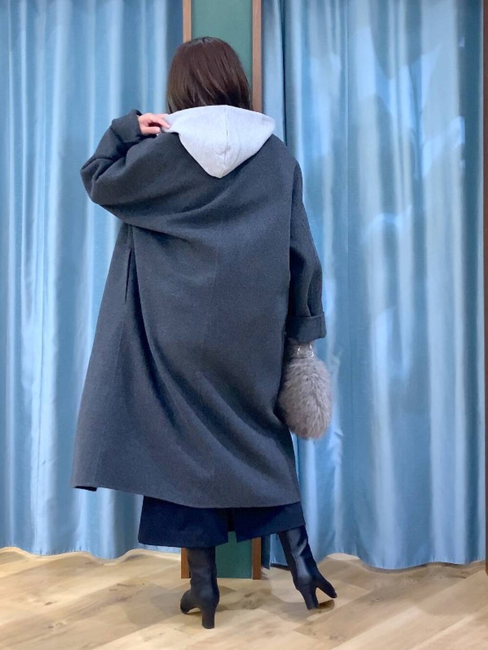 ブラウン系のトートバッグ、グレー系のチェスターコート、ブラック系のスカートを着用したレディースの秋コーディネートの5枚目の写真