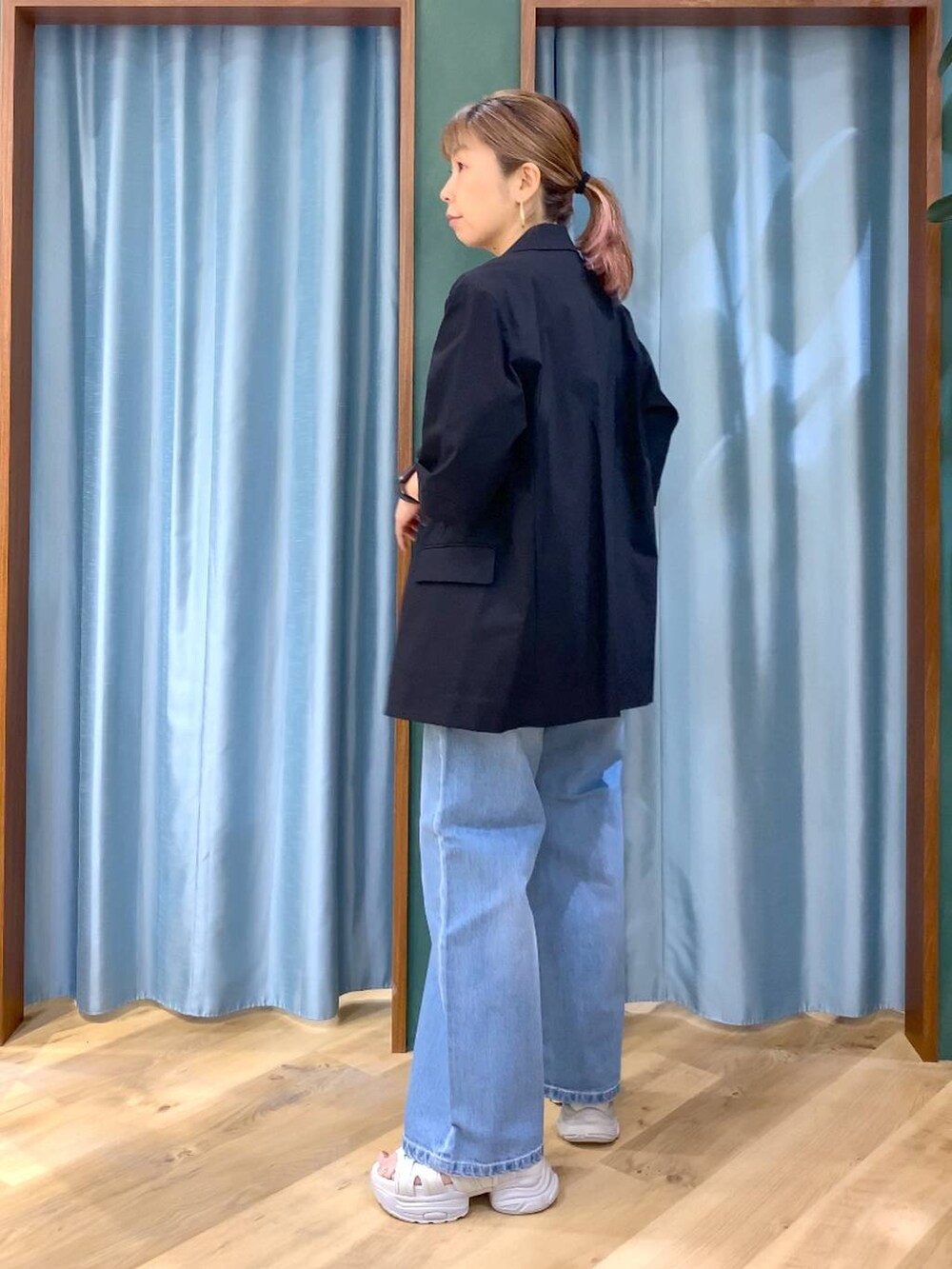 ブルー系のデニムパンツ、ホワイト系のタンクトップ、ブラック系のテーラードジャケットを着用したレディースの春コーディネートの4枚目の写真