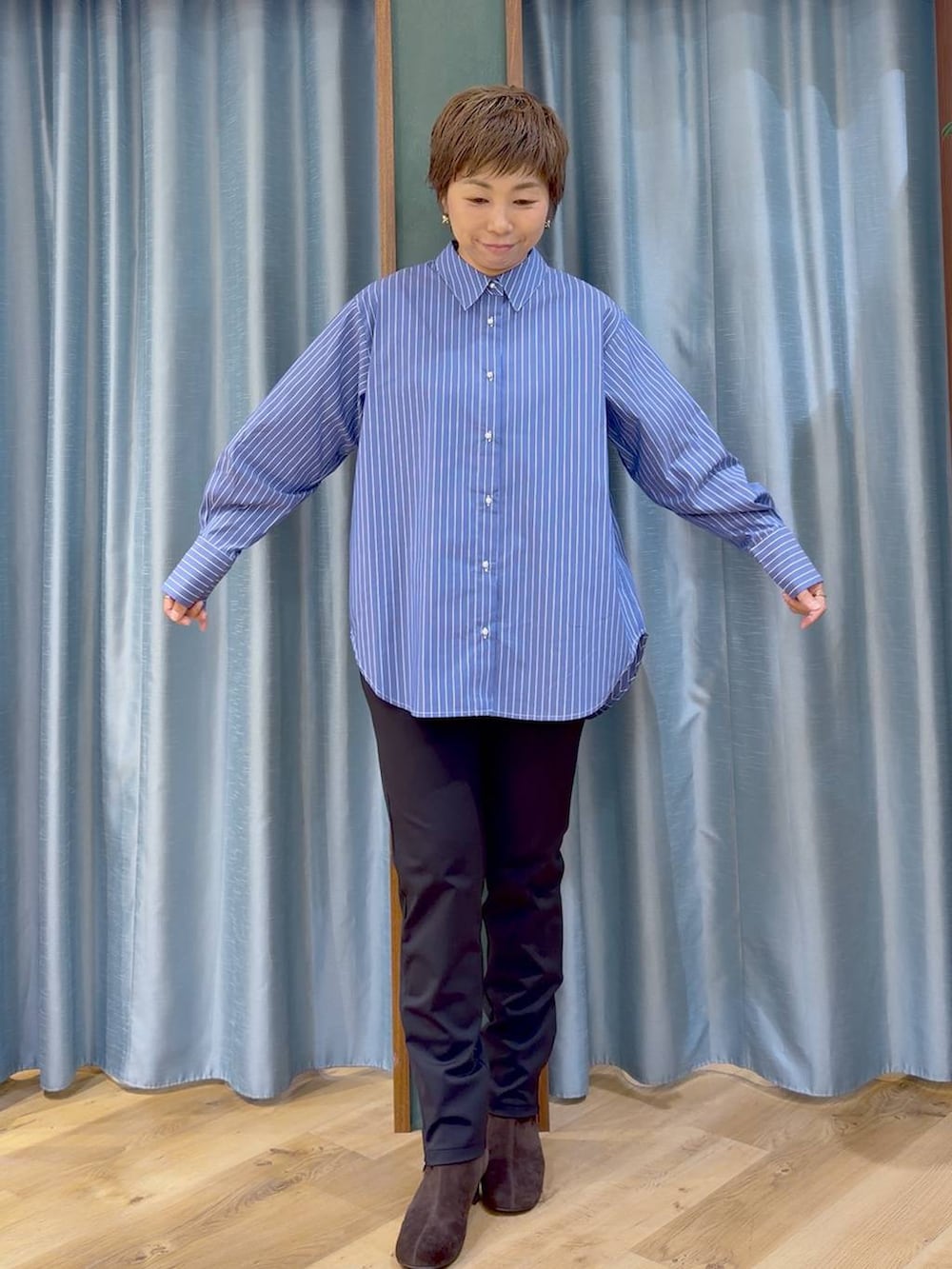 ブラック系のその他パンツ、ブラウン系のブーツ、ブルー系のシャツ/ブラウスを着用したレディースの秋コーディネートの9枚目の写真