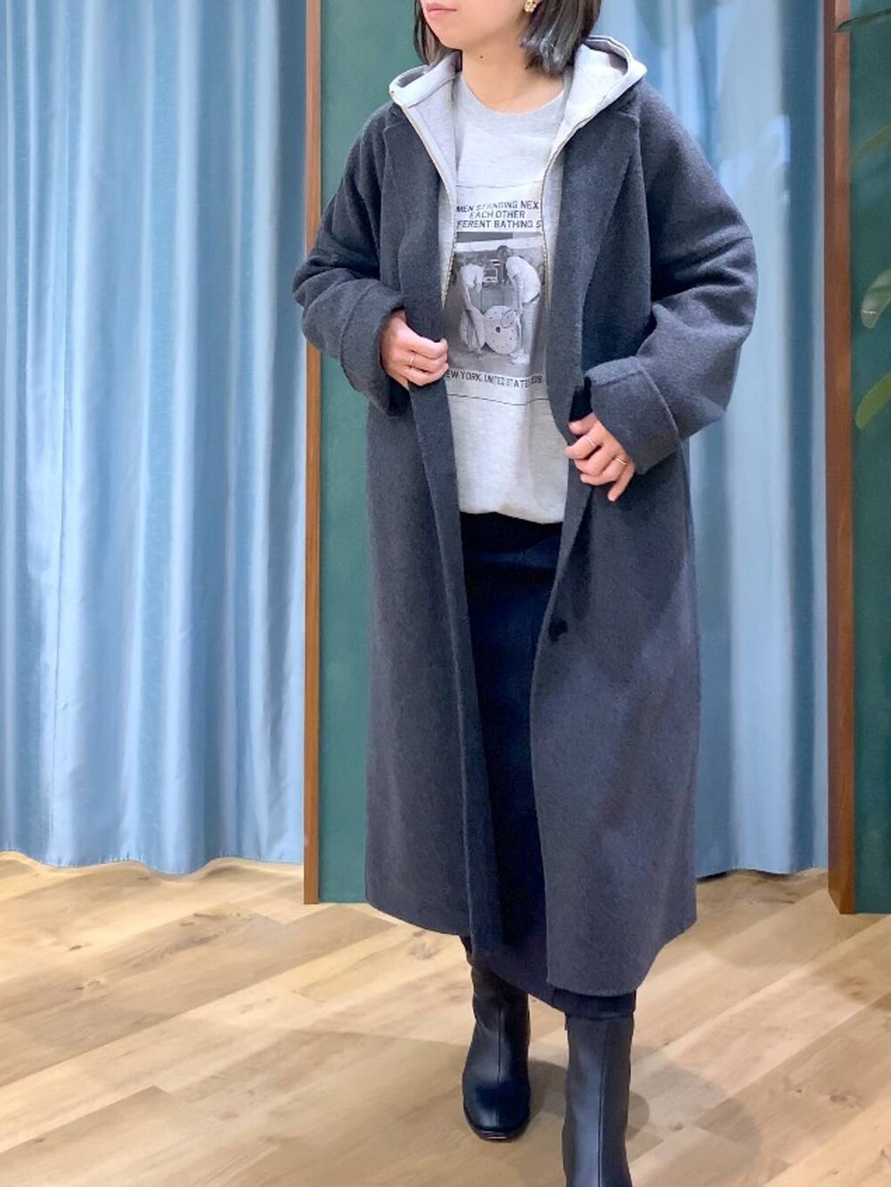 ブラウン系のトートバッグ、グレー系のチェスターコート、ブラック系のスカートを着用したレディースの秋コーディネートの8枚目の写真