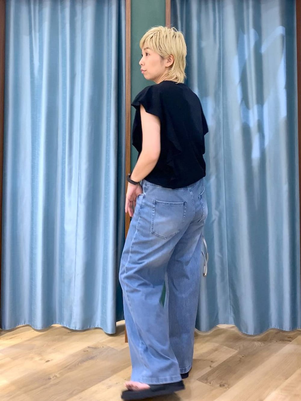 ブルー系のデニムパンツ、シルバー系のショルダーバッグ、ブラック系のニット/セーターを着用したレディースの夏コーディネートの4枚目の写真