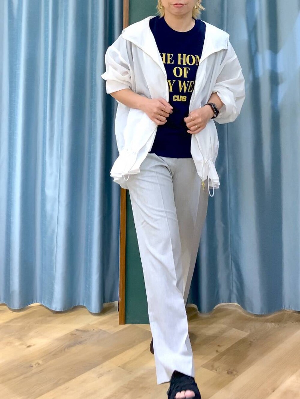 ブルー系のTシャツ/カットソー、ブラック系のサンダル、ホワイト系のブルゾンを着用したレディースの夏コーディネートの8枚目の写真