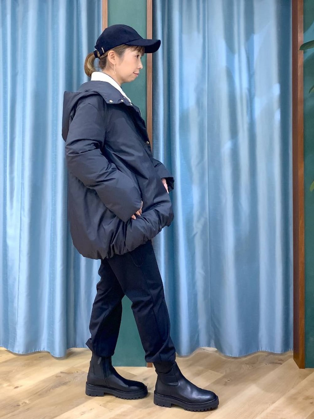 ブラック系のブーツ、ホワイト系のニット/セーター、ブルー系のシャツ/ブラウスを着用したレディースの冬コーディネートの3枚目の写真