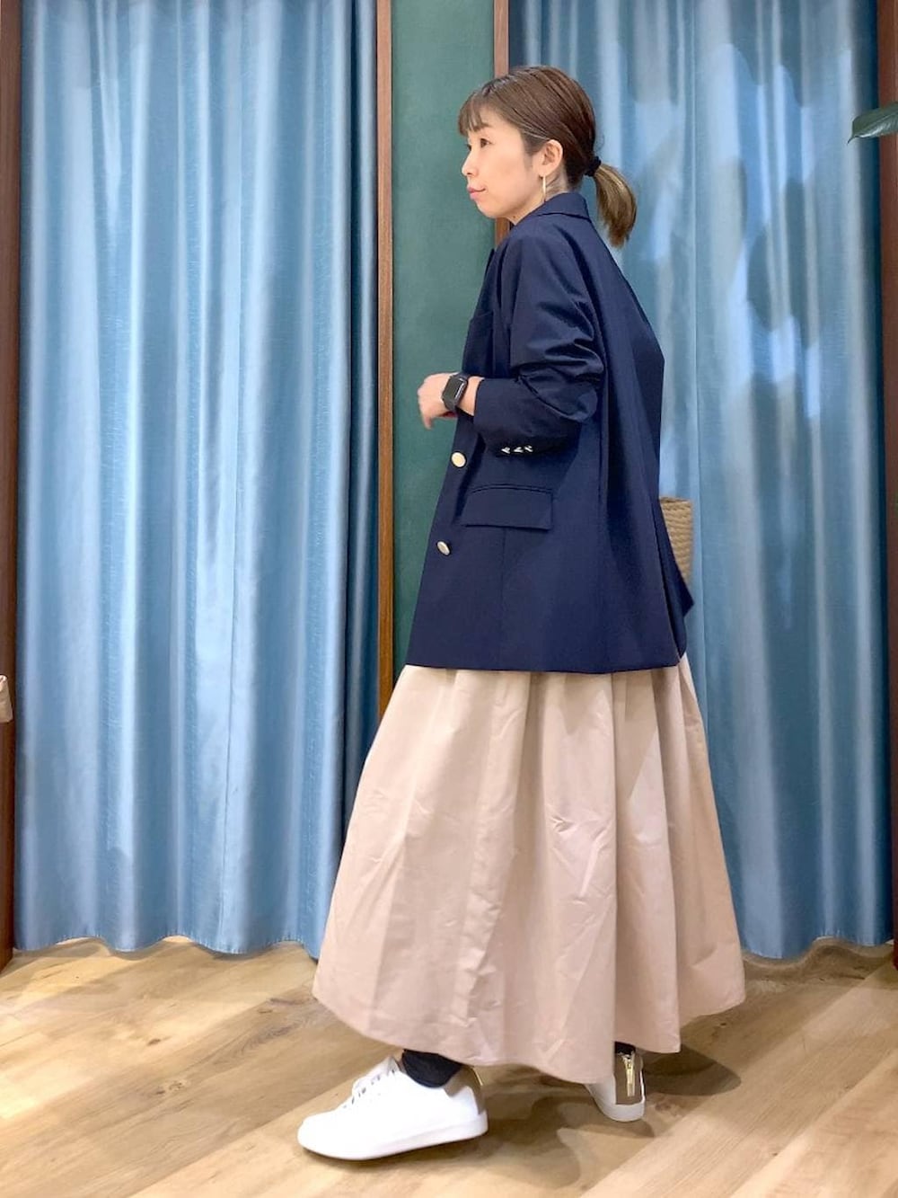 ベージュ系のスカート、ブルー系のテーラードジャケット、ベージュ系のトートバッグを着用したレディースの冬コーディネートの3枚目の写真