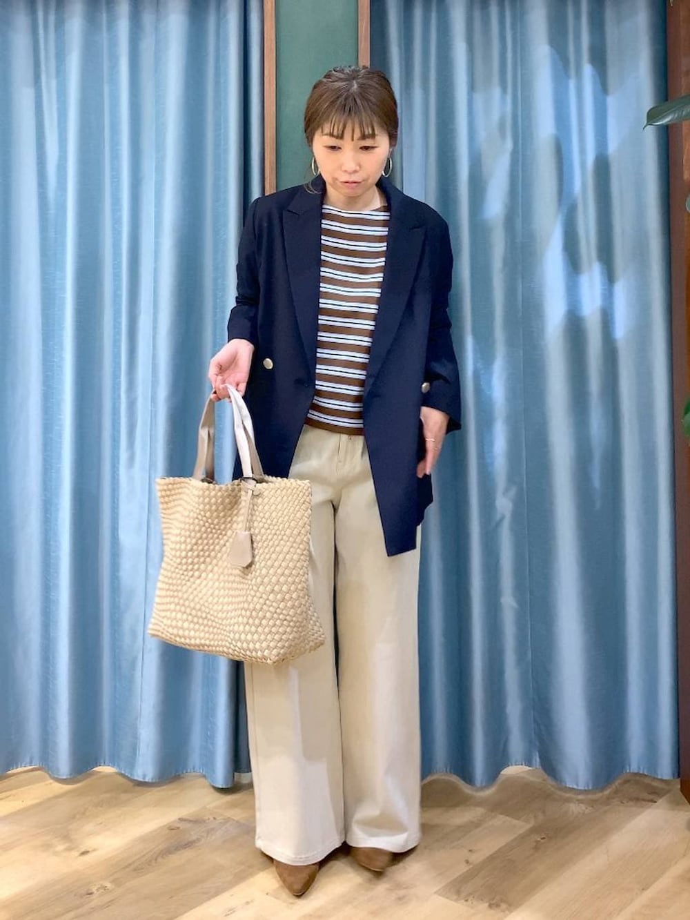 ブラウン系のTシャツ/カットソー、ベージュ系のデニムパンツ、ブルー系のテーラードジャケットを着用したレディースの冬コーディネートの2枚目の写真