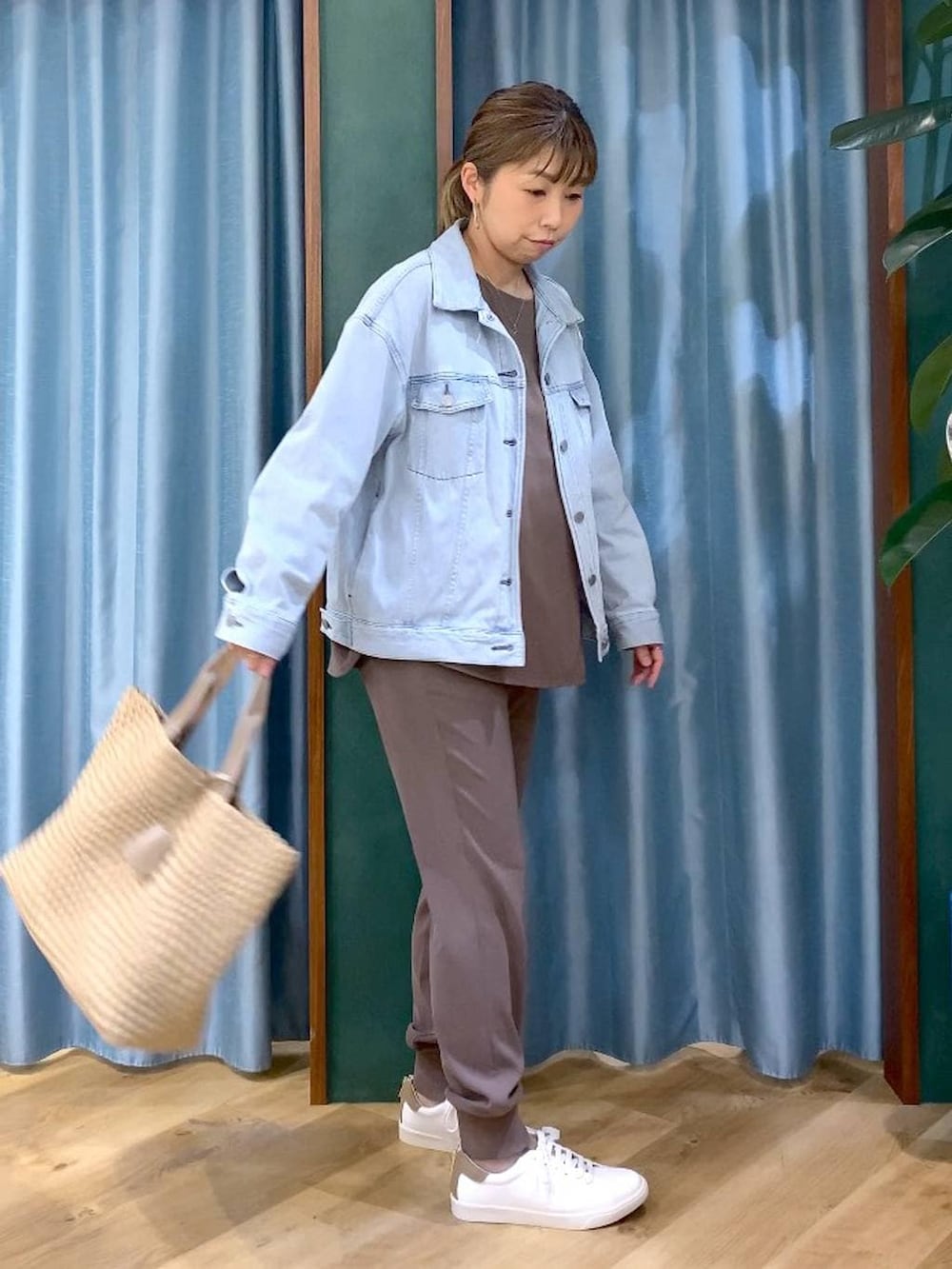 ブルー系のデニムジャケット、グリーン系のTシャツ/カットソー、ベージュ系のトートバッグを着用したレディースの冬コーディネートの5枚目の写真