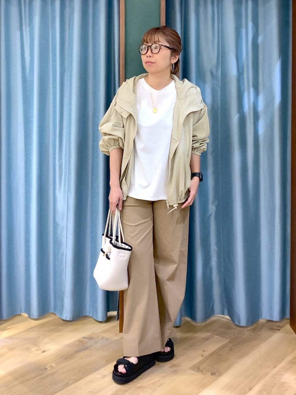 ホワイト系のTシャツ/カットソー、ベージュ系のその他パンツ、ベージュ系のブルゾンを着用したレディースの春コーディネートの3枚目の写真