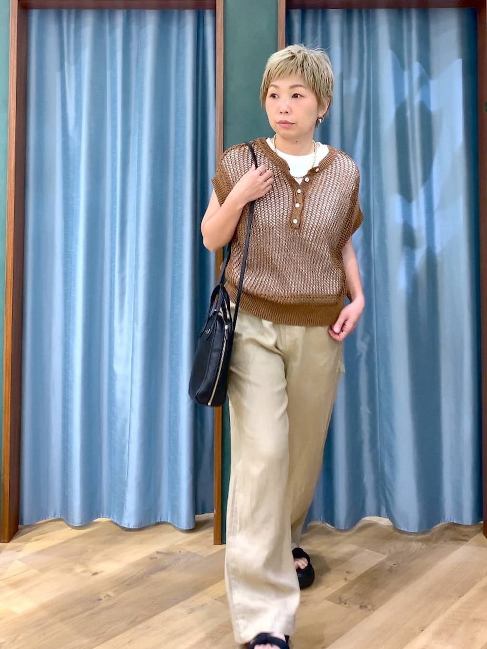 ホワイト系のTシャツ/カットソー、ベージュ系のその他パンツ、ブラック系のショルダーバッグを着用したレディースの夏コーディネートの4枚目の写真