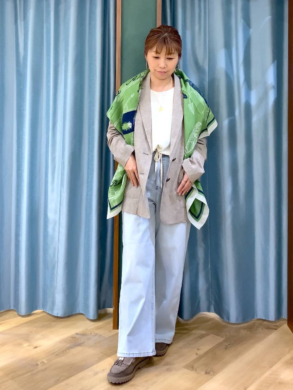 グレー系のローファー、ブルー系のデニムパンツ、ベージュ系のテーラードジャケットを着用したレディースの春コーディネートの2枚目の写真