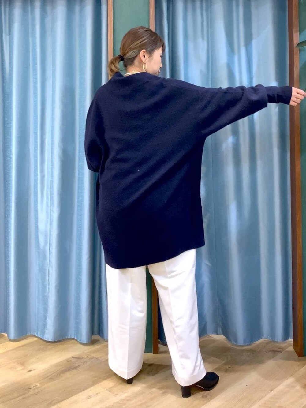 ベージュ系のトートバッグ、ブラック系のブーツ、ブルー系のニット/セーターを着用したレディースの冬コーディネートの4枚目の写真