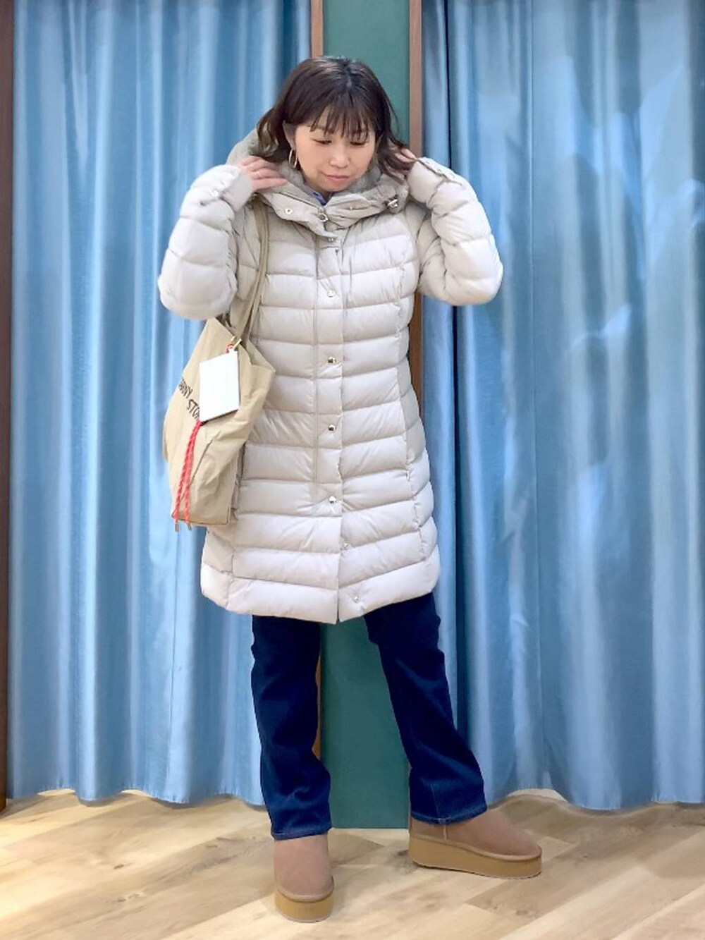 ベージュ系のトートバッグ、ブルー系のシャツ/ブラウス、ブルー系のデニムパンツを着用したレディースの秋コーディネートの2枚目の写真