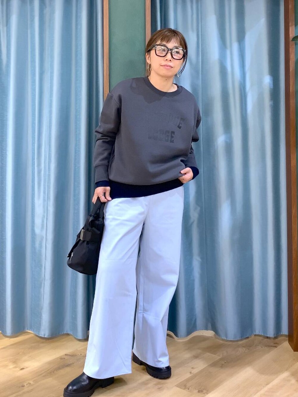 ブラック系のブーツ、ブラック系のショルダーバッグ、ブルー系のニット/セーターを着用したレディースの秋コーディネートの5枚目の写真