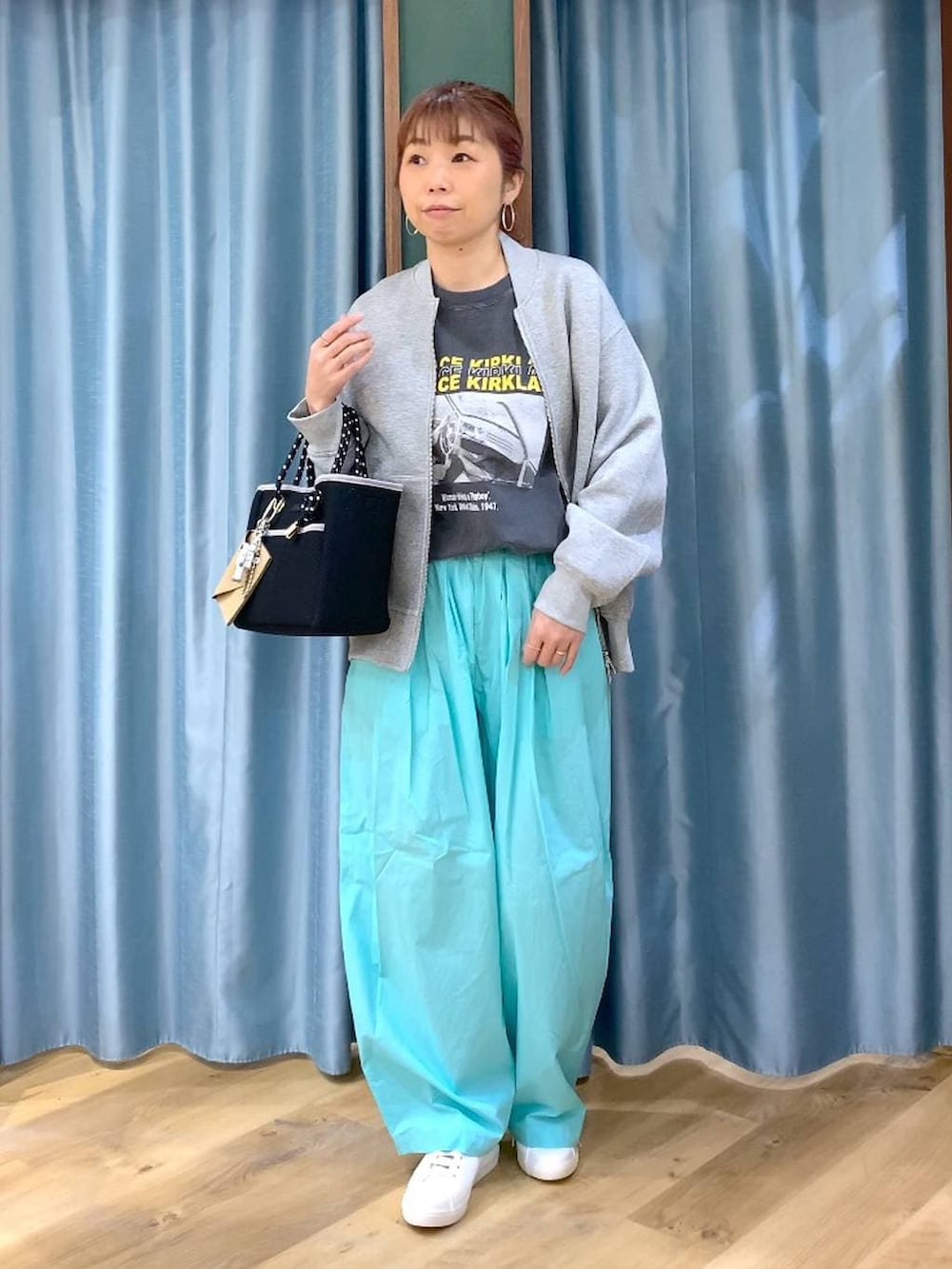 グリーン系のその他パンツ、グレー系のブルゾン、ブラウン系のスニーカーを着用したレディースの春コーディネートの2枚目の写真