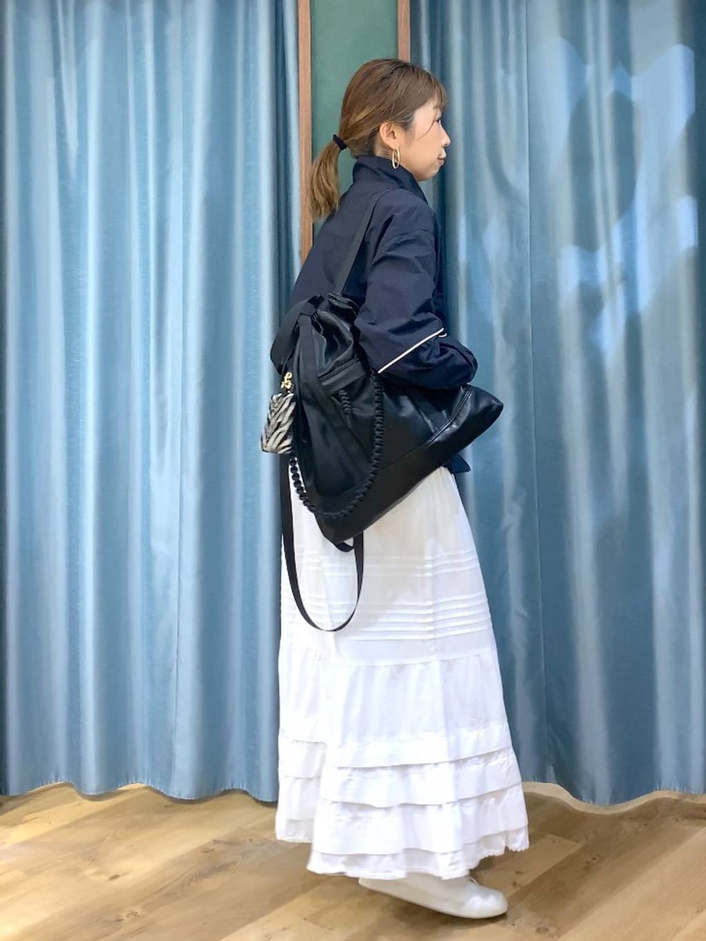 ブラック系のバックパック/リュック、ブルー系のナイロンジャケット、ブラウン系のスニーカーを着用したレディースの冬コーディネートの6枚目の写真