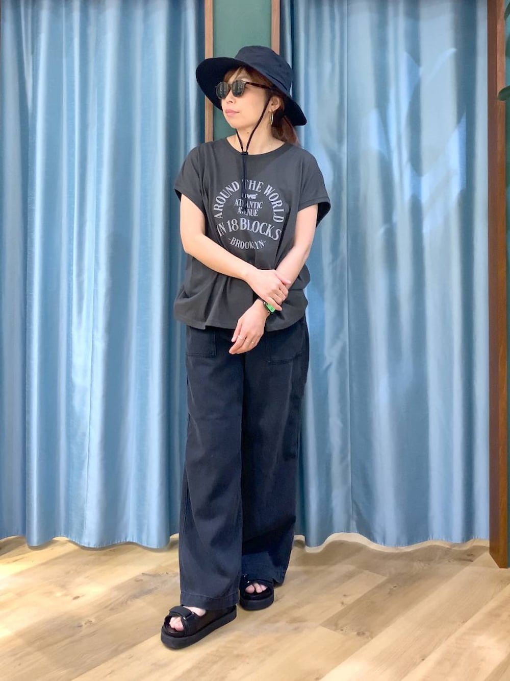 ブラック系のTシャツ/カットソー、グレー系のデニムパンツ、ブラック系のサンダルを着用したレディースの春コーディネートの3枚目の写真