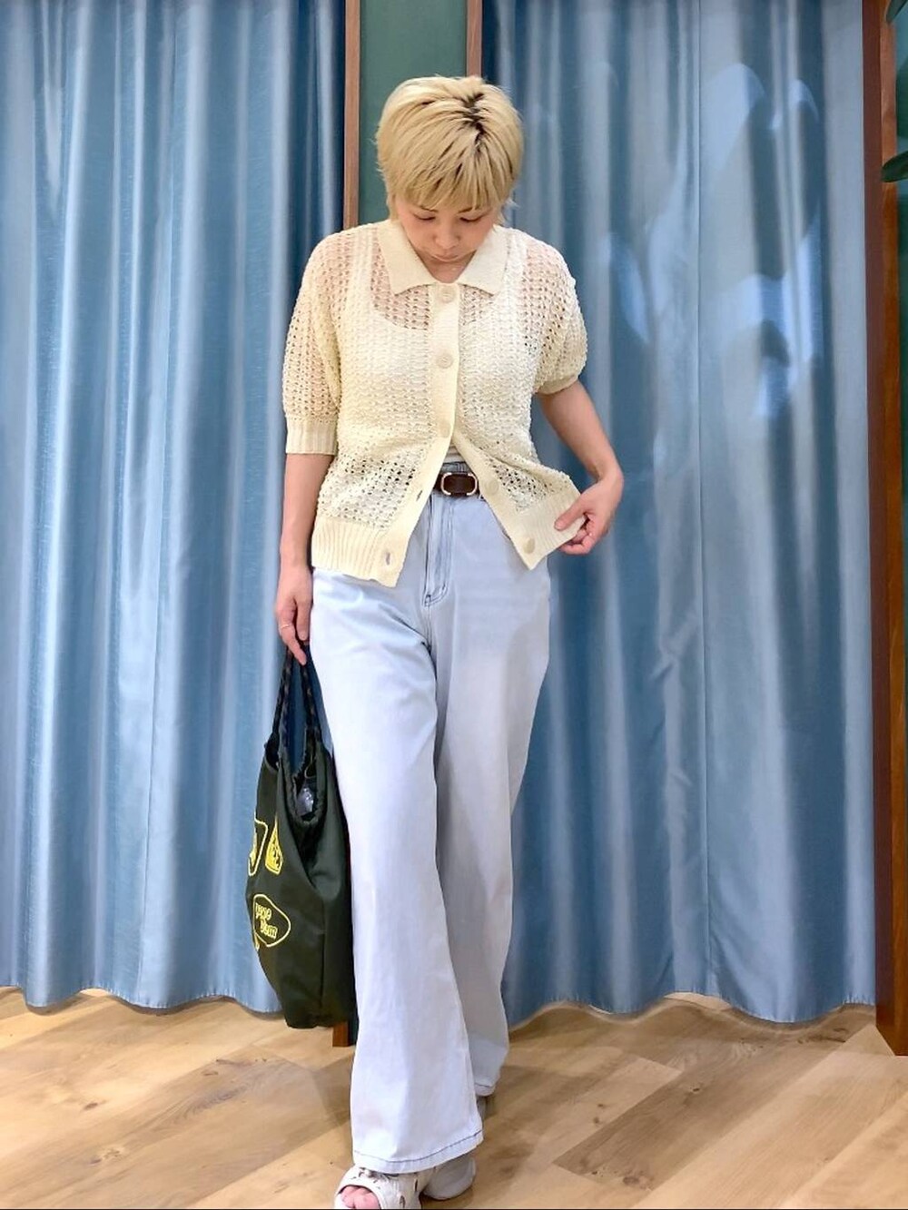 ホワイト系のタンクトップ、ブルー系のデニムパンツ、ホワイト系のニット/セーターを着用したレディースの夏コーディネートの4枚目の写真